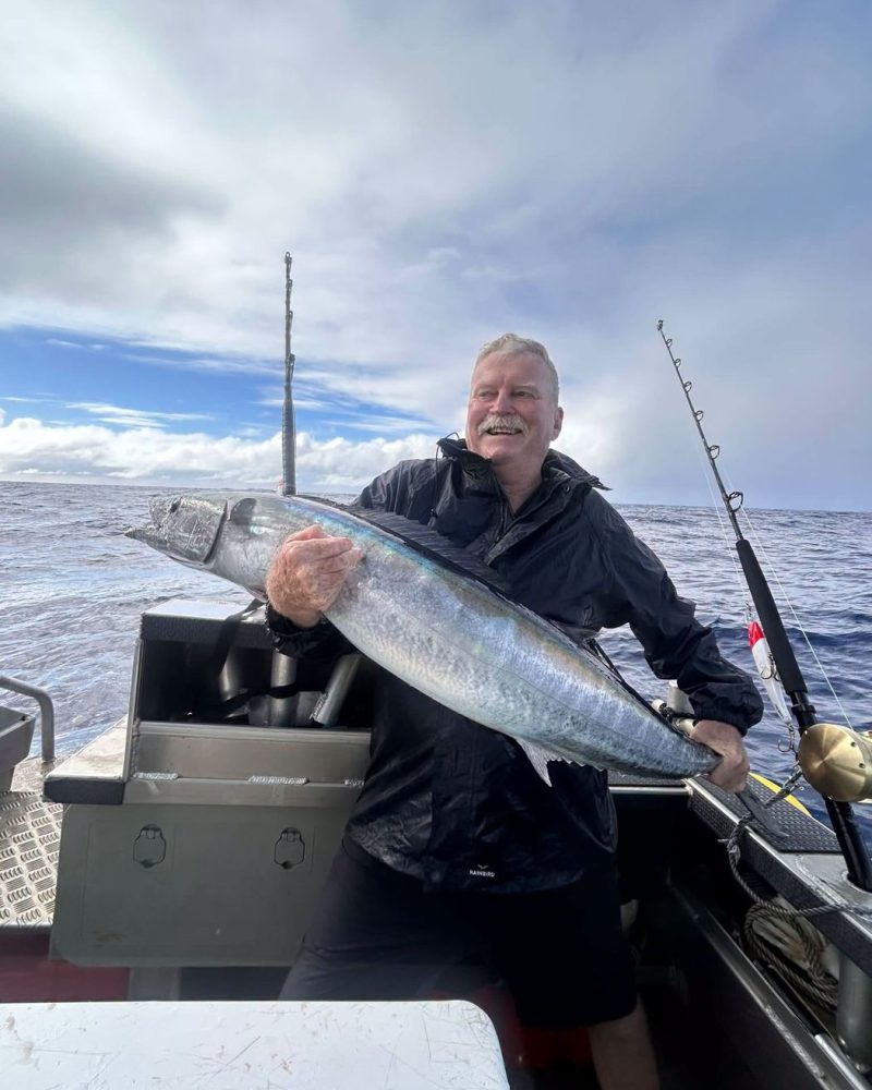 An angler with a big catch on a grey day