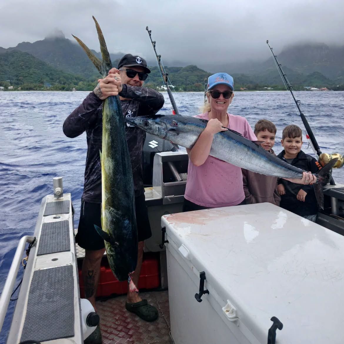 A family on board with a mahi-mahi and a wahoo