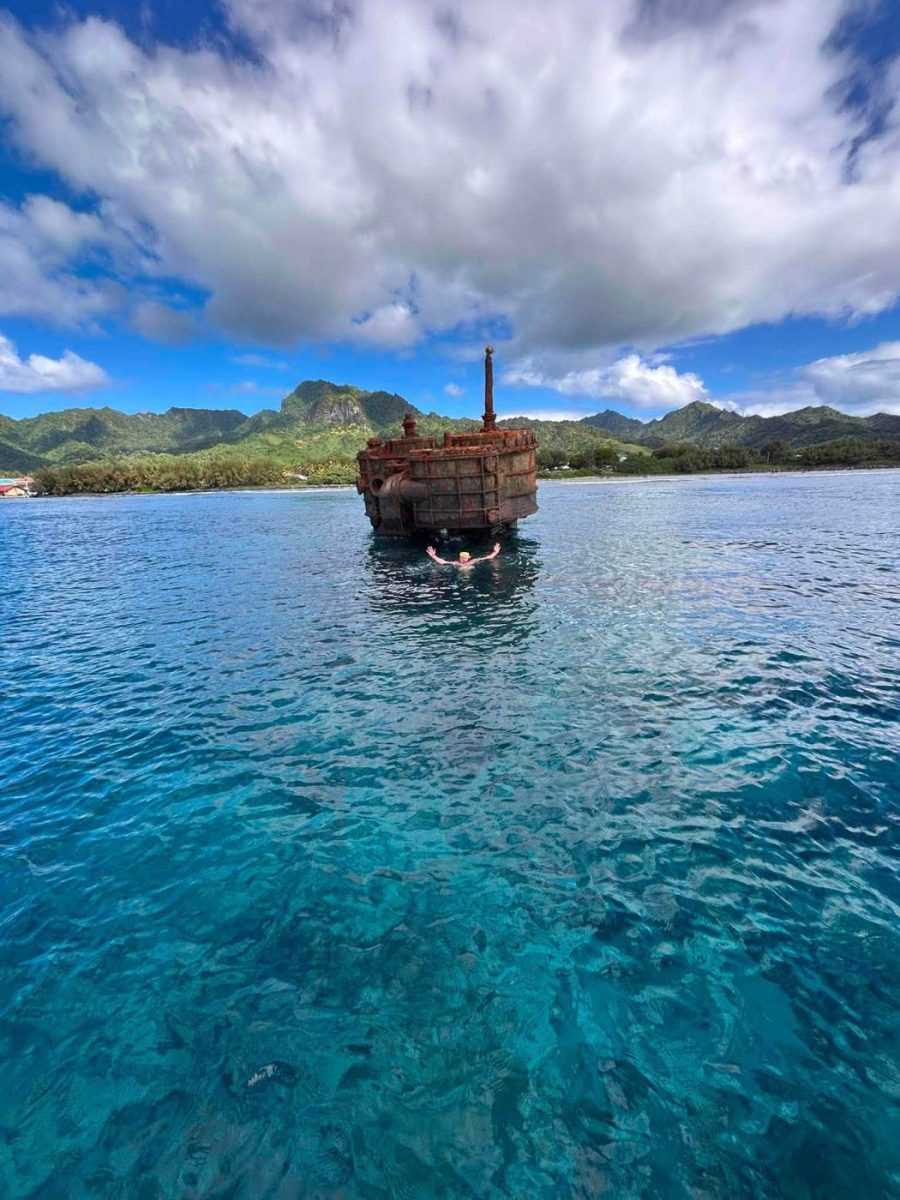 A swimmer beside the old wreck in clear blue water